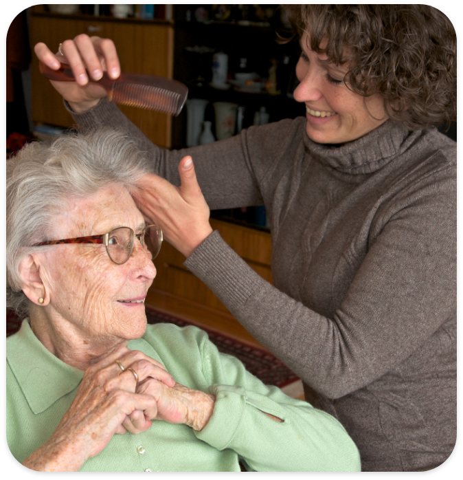 Elderly carer looking after woman with Parkinsons