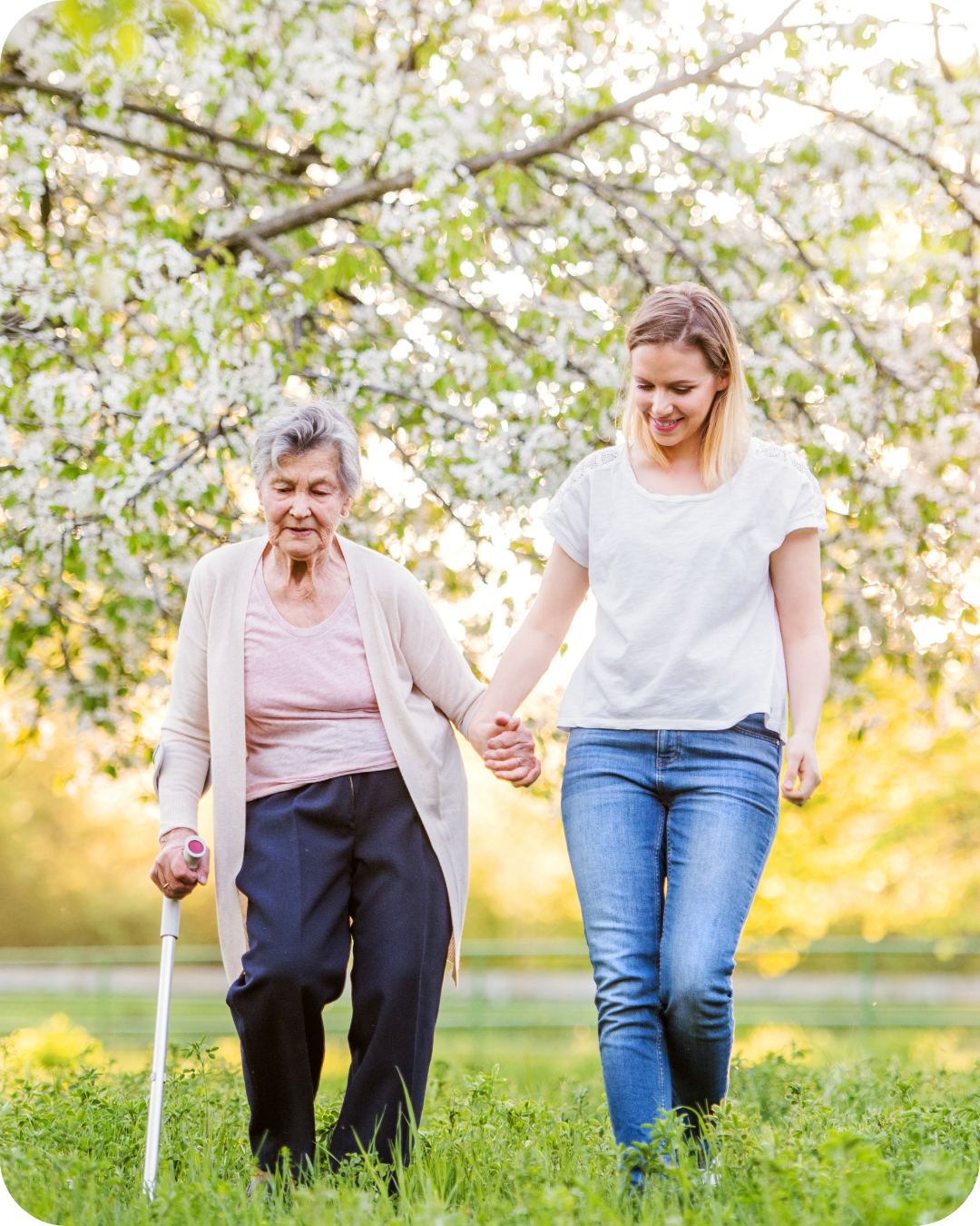 Elderly woman walking in park with live in carer