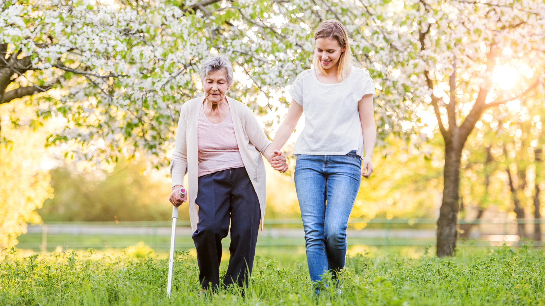 Young carer with elderly taking a walk outside